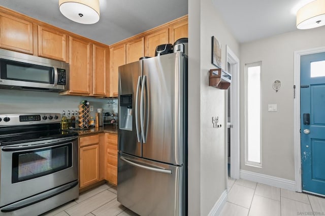 kitchen with light tile patterned floors and appliances with stainless steel finishes