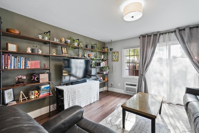 living room with a wall mounted AC and hardwood / wood-style flooring