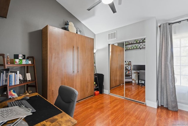 office space featuring ceiling fan, vaulted ceiling, plenty of natural light, and light hardwood / wood-style floors