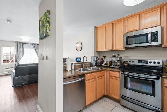 kitchen featuring light hardwood / wood-style flooring, sink, stainless steel appliances, and a wall unit AC