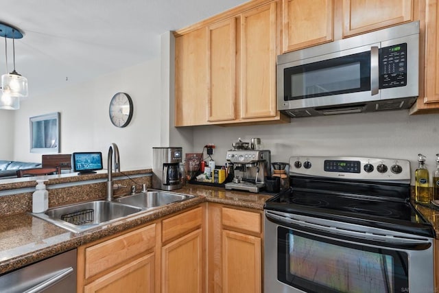 kitchen with sink, light brown cabinets, appliances with stainless steel finishes, and hanging light fixtures