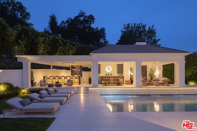 view of pool featuring exterior bar and a patio