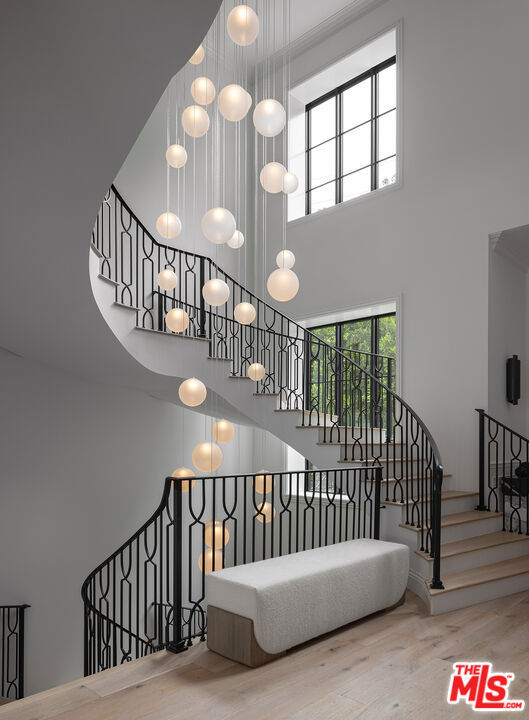 staircase with a high ceiling and hardwood / wood-style flooring