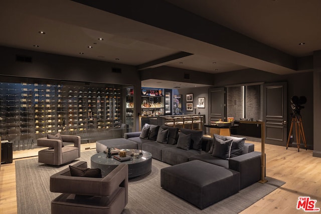 home theater room with bar area and light hardwood / wood-style flooring