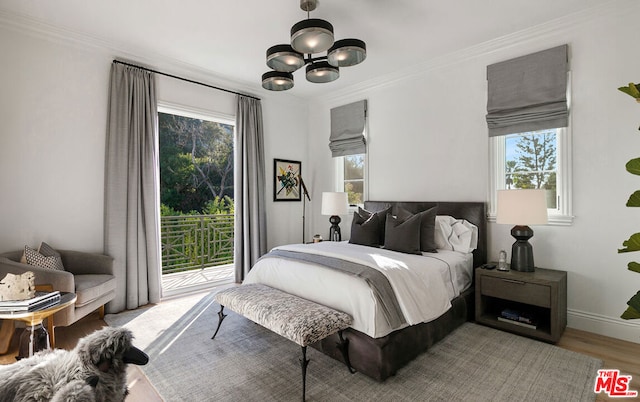 bedroom with access to outside, ornamental molding, multiple windows, and hardwood / wood-style flooring