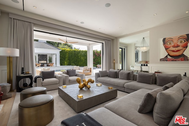 living room with ceiling fan with notable chandelier