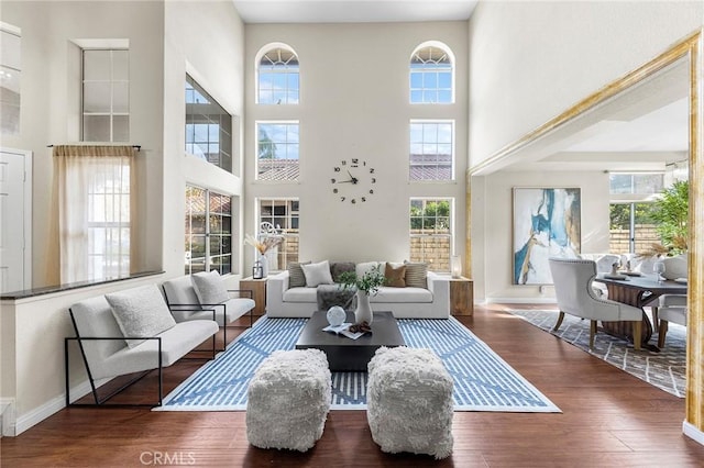 living room featuring dark wood-type flooring and a towering ceiling