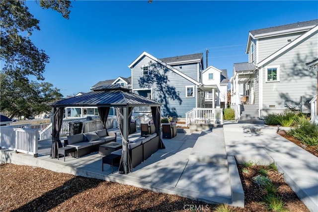 back of property with an outdoor hangout area, a patio area, and a gazebo