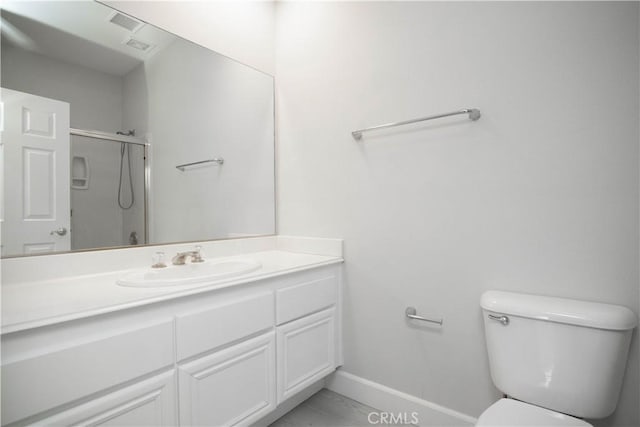 bathroom with toilet, an enclosed shower, and vanity