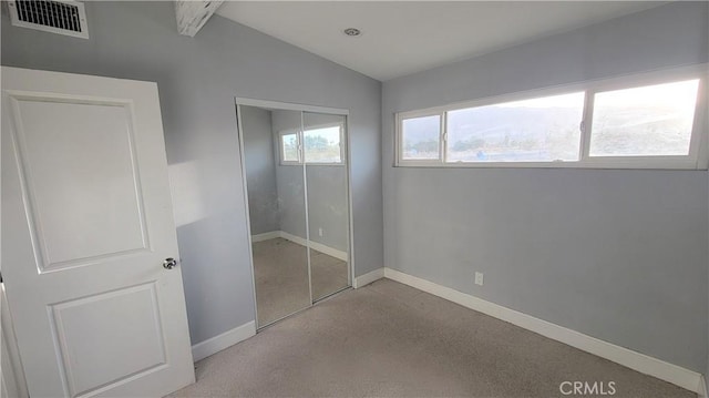 unfurnished bedroom featuring lofted ceiling and a closet