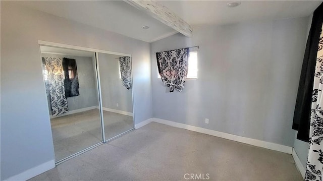 unfurnished bedroom with vaulted ceiling with beams and a closet