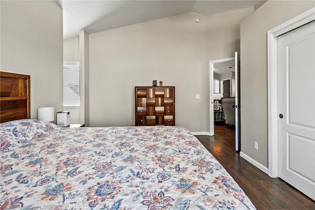 bedroom with vaulted ceiling, a closet, and dark hardwood / wood-style flooring