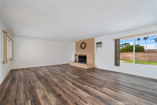 unfurnished living room featuring a fireplace, dark hardwood / wood-style floors, and a textured ceiling