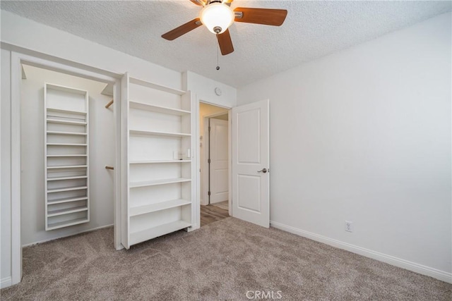 unfurnished bedroom with ceiling fan, light colored carpet, and a textured ceiling