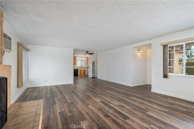 unfurnished living room with ceiling fan, dark hardwood / wood-style floors, plenty of natural light, and a fireplace