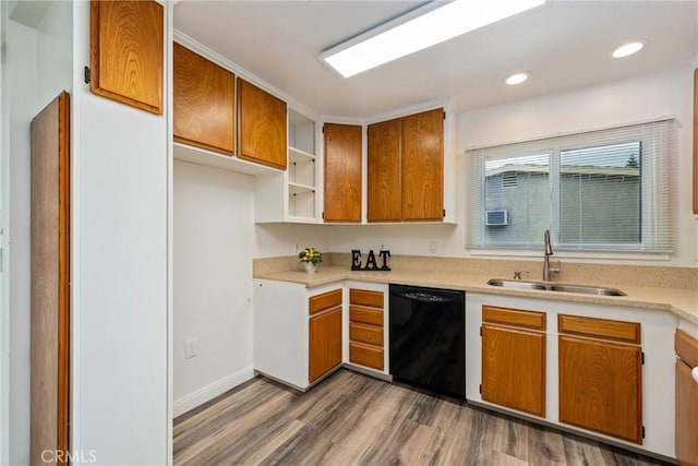 kitchen with wood-type flooring, sink, crown molding, and black dishwasher