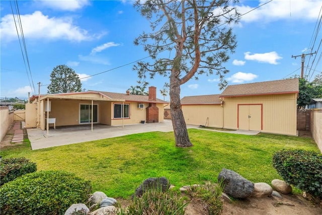 back of property with a patio area and a yard