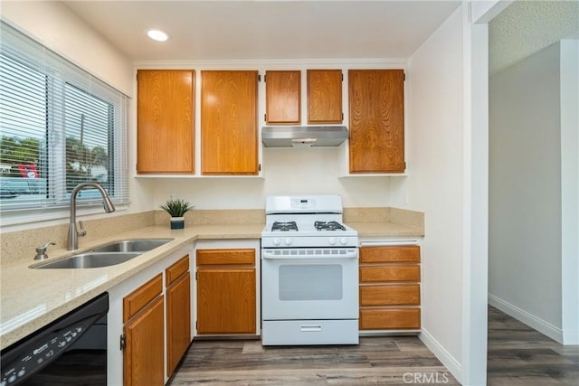 kitchen with dark wood-type flooring, dishwasher, white gas range oven, and sink