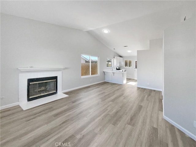 unfurnished living room with lofted ceiling and light wood-type flooring