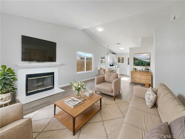 living room featuring lofted ceiling and light hardwood / wood-style floors