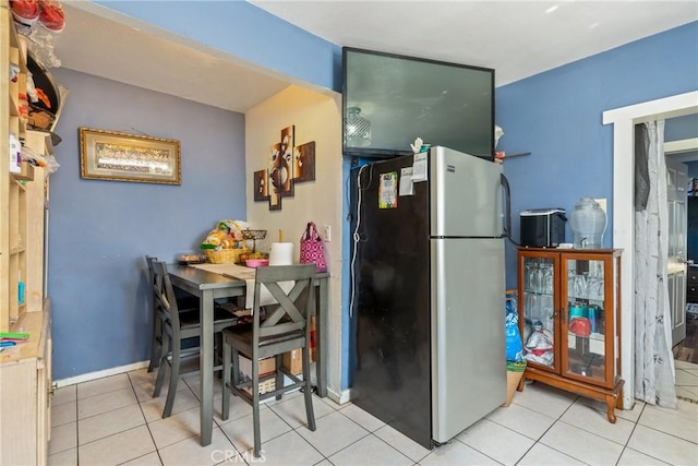 kitchen featuring stainless steel fridge and light tile patterned flooring