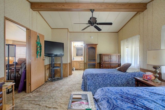 bedroom with ceiling fan, light colored carpet, ensuite bathroom, vaulted ceiling with beams, and wooden walls