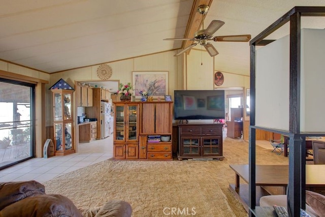 living room featuring ceiling fan, light tile patterned floors, and vaulted ceiling