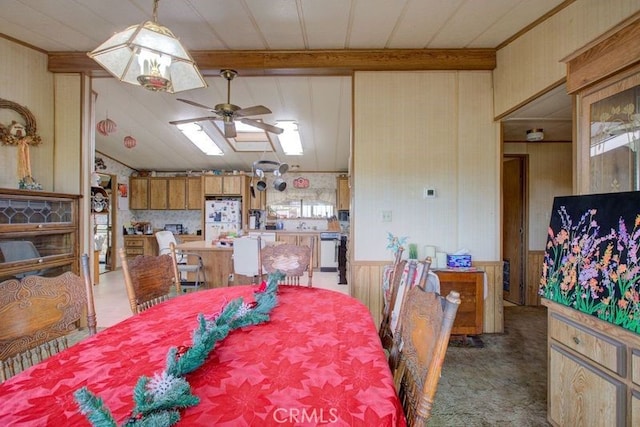 carpeted dining space featuring ceiling fan and wood walls