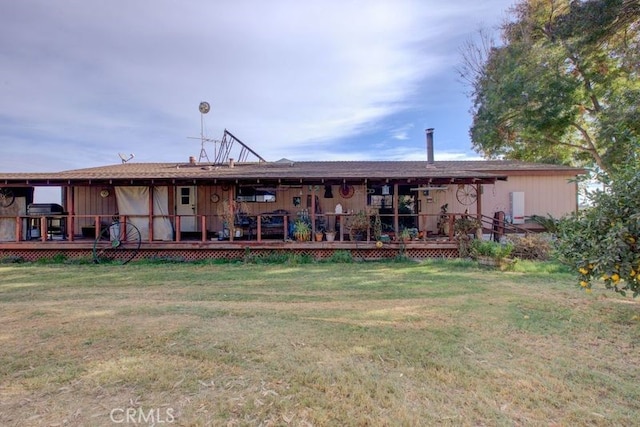 rear view of house featuring a wooden deck and a yard