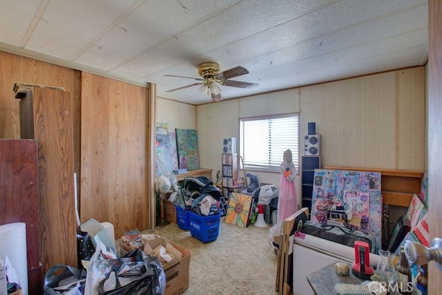 miscellaneous room featuring carpet floors, ceiling fan, and wooden walls