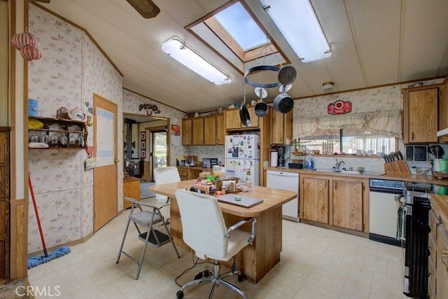 kitchen with vaulted ceiling with skylight, sink, and white appliances