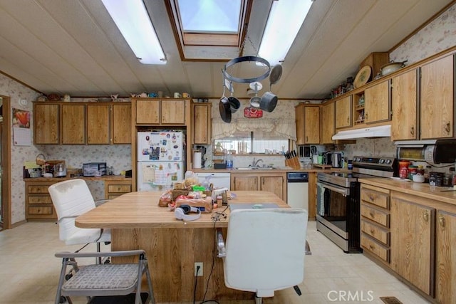 kitchen featuring vaulted ceiling with skylight, sink, a center island, and white appliances