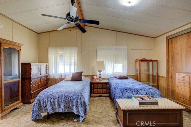 carpeted bedroom with ceiling fan, wood walls, and vaulted ceiling