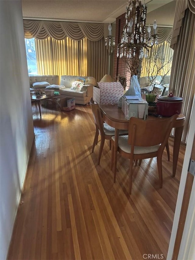 dining space featuring hardwood / wood-style flooring and a chandelier