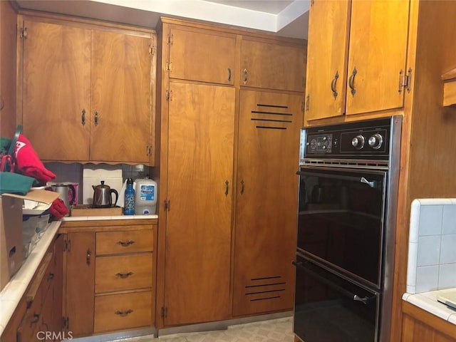 kitchen with black double oven and backsplash