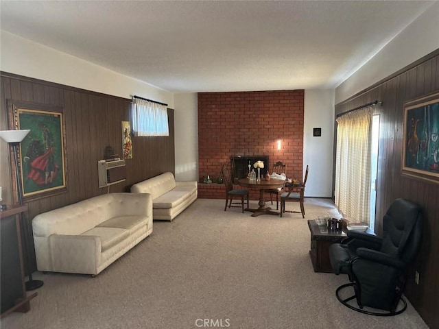 carpeted living room featuring a fireplace and wooden walls