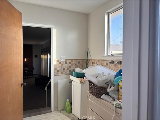 laundry area with tile walls