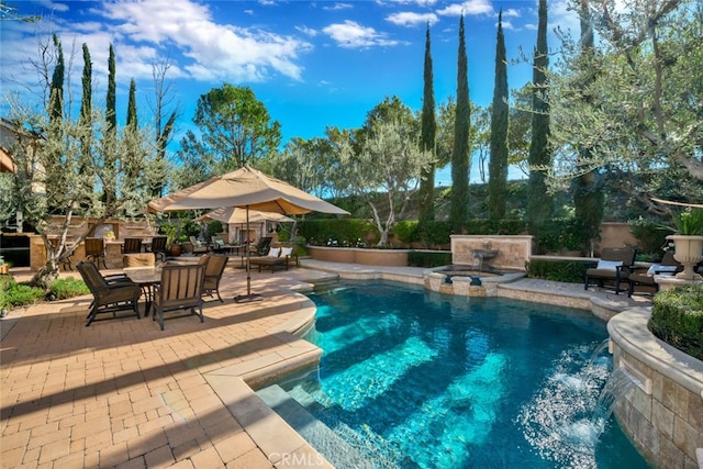 view of swimming pool featuring pool water feature and a patio