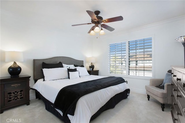 carpeted bedroom with ornamental molding and ceiling fan