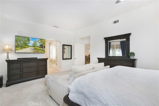 carpeted bedroom with ornamental molding and ensuite bath