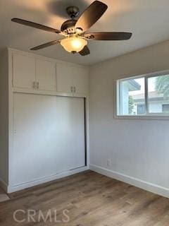 unfurnished bedroom with ceiling fan, a closet, and light hardwood / wood-style flooring