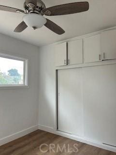 unfurnished bedroom with ceiling fan and dark hardwood / wood-style floors