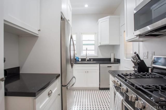 kitchen with appliances with stainless steel finishes, white cabinets, and sink