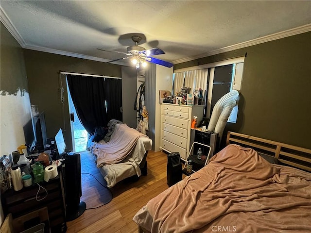 bedroom featuring light wood-type flooring, ceiling fan, and crown molding