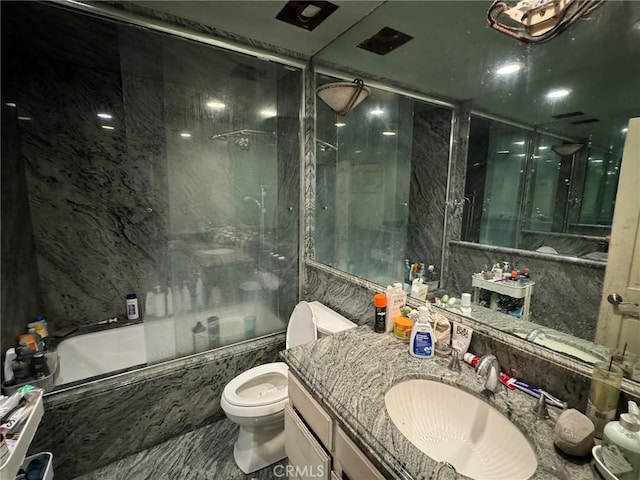 full bathroom with toilet, bath / shower combo with glass door, and vanity