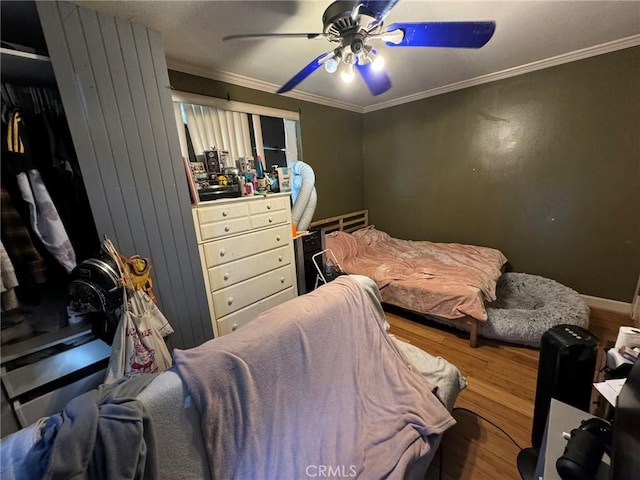 bedroom featuring ceiling fan, hardwood / wood-style flooring, and crown molding