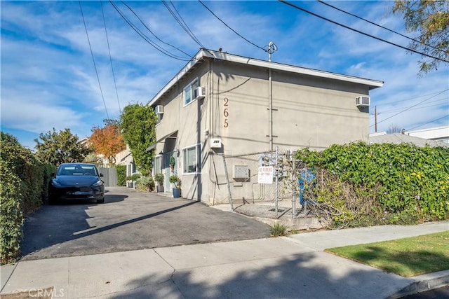 view of home's exterior featuring a wall mounted air conditioner