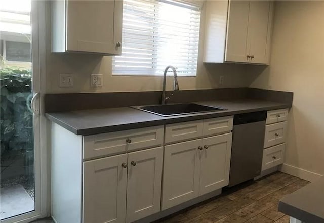 kitchen featuring dark wood-type flooring, white cabinets, dishwasher, and sink