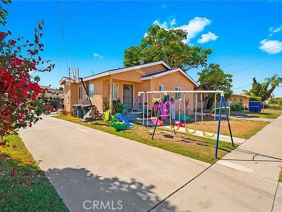 view of front of house featuring a playground and a front lawn