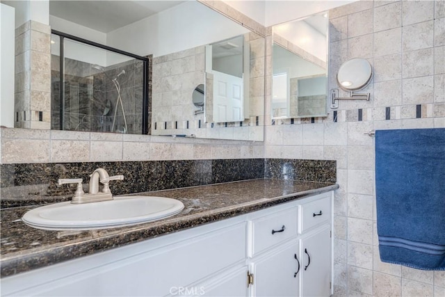 bathroom with vanity, an enclosed shower, and decorative backsplash